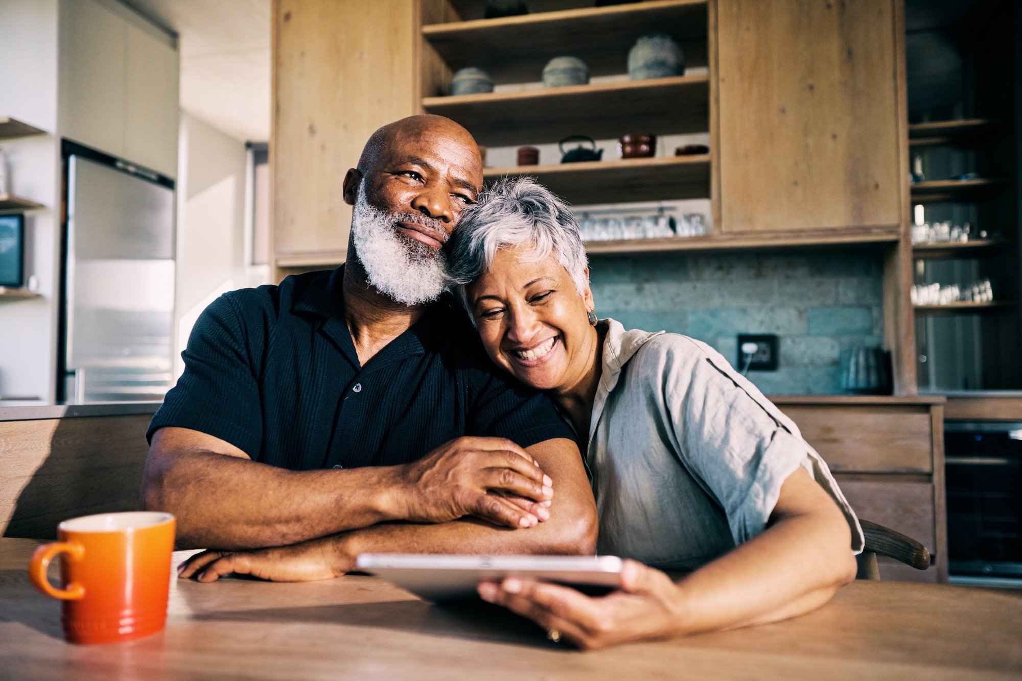 Couple sharing a laugh at the kitchen counter Couple sharing a laugh at the kitchen counter